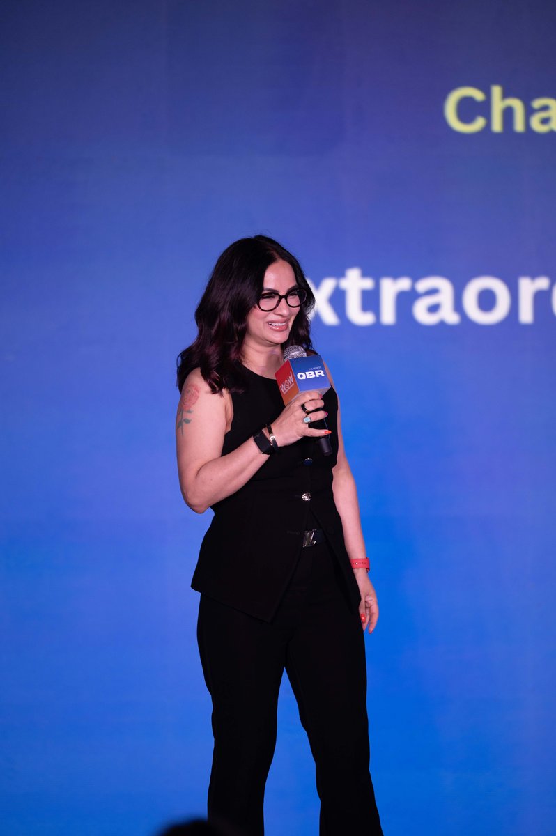 Roopali Talwar delivering a keynote on stage with a microphone