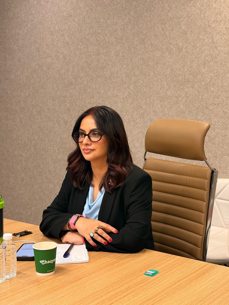 Roopali Talwar, mindset coach and speaker, at her desk in a black blazer