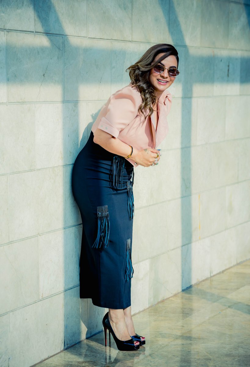 Roopali Talwar smiling, leaning against a wall